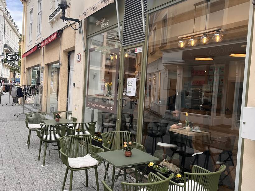 Die salbeigrünen Bistrostühle und Tische von Simple Day&rsquo;s in der Fußgängerzone Theresiengasse