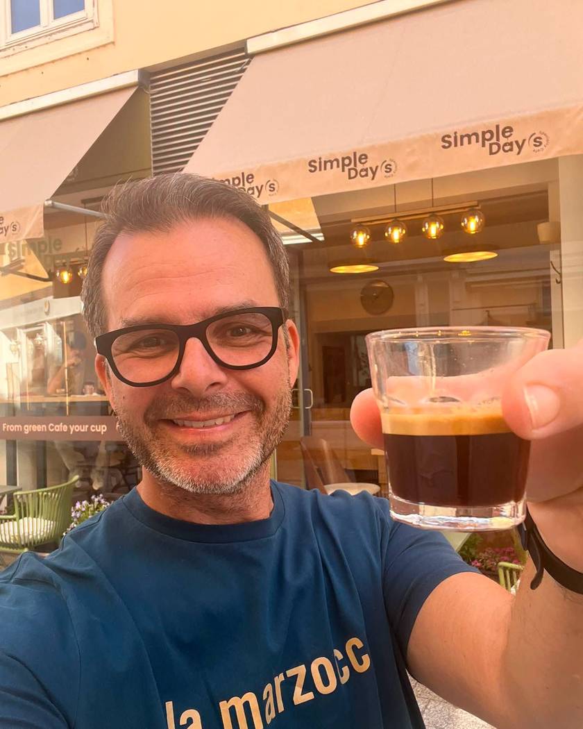 Der Inhaber vor seinem Café unter der Markise mit dem Simple-Day’s-Schriftzug, in der Hand ein frisch gezogener Espresso