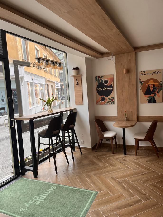 Innenraum mit Fischgrätparkett, hellem Holz, Fensterbanktisch und der Fußmatte mit dem Hauslogo